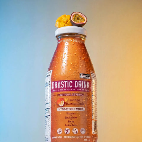 Bottle of Drastic Drink with mango and passionfruit on a gradient background